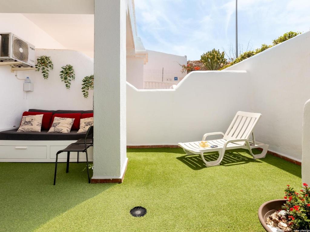 a small balcony with green carpet on the floor at Port Royale 291, Spacious Studio in Los Cristianos