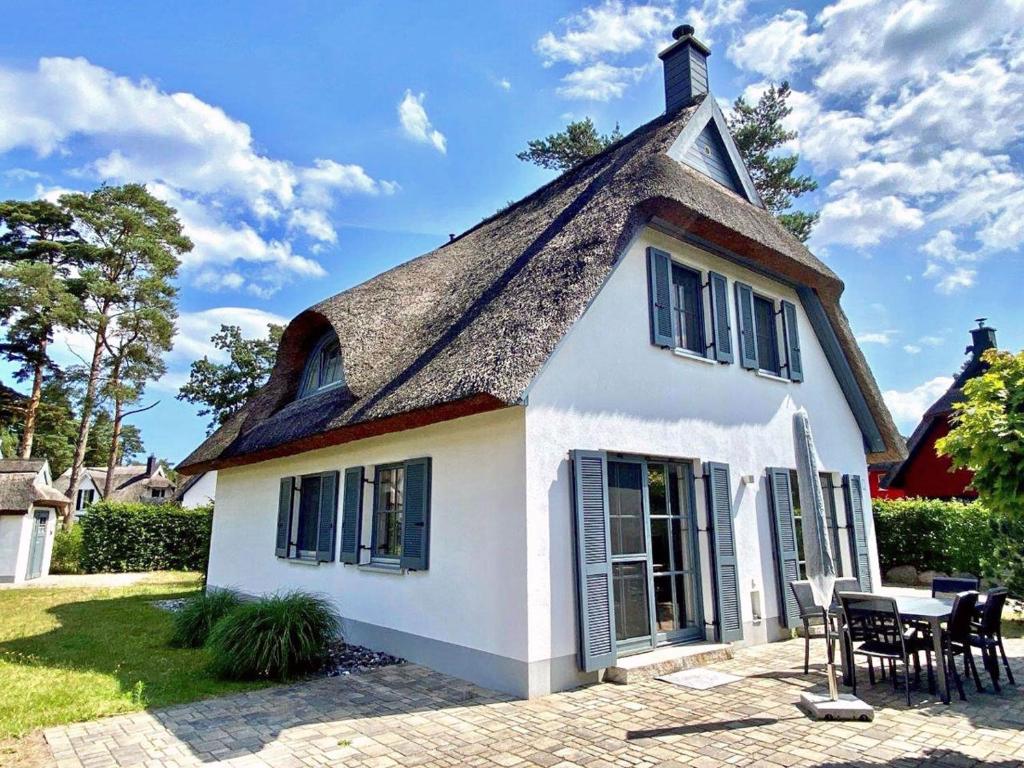 a small white house with a thatched roof at Sterntaucher in Klein Gelm