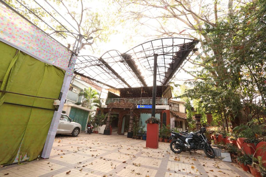 a building with a motorcycle parked on a street at FabHotel Maruthi Residency in Hyderabad