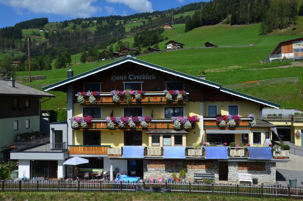 a large building with flowers on the balcony at Haus Ortsblick in Wagrain