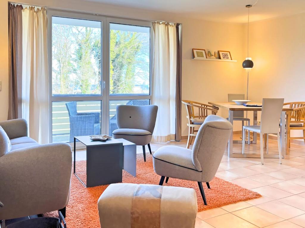 - un salon avec des chaises et une salle à manger dans l'établissement Residenz am Strand, Whg 238, à Zingst