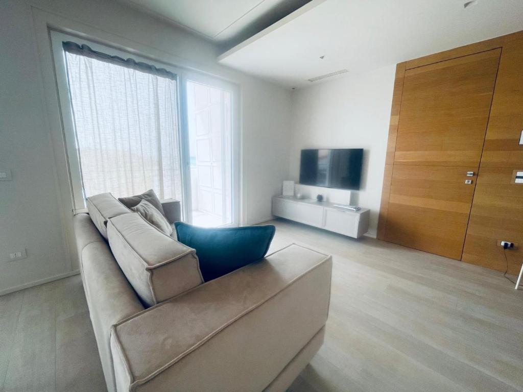een woonkamer met een bank en een televisie bij Appartamento Punta Grande - Scala dei Turchi in Realmonte