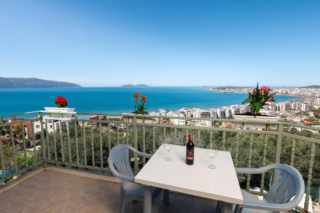 Una mesa blanca y sillas en un balcón con vista al mar. en Lorel's Homes, en Vlorë