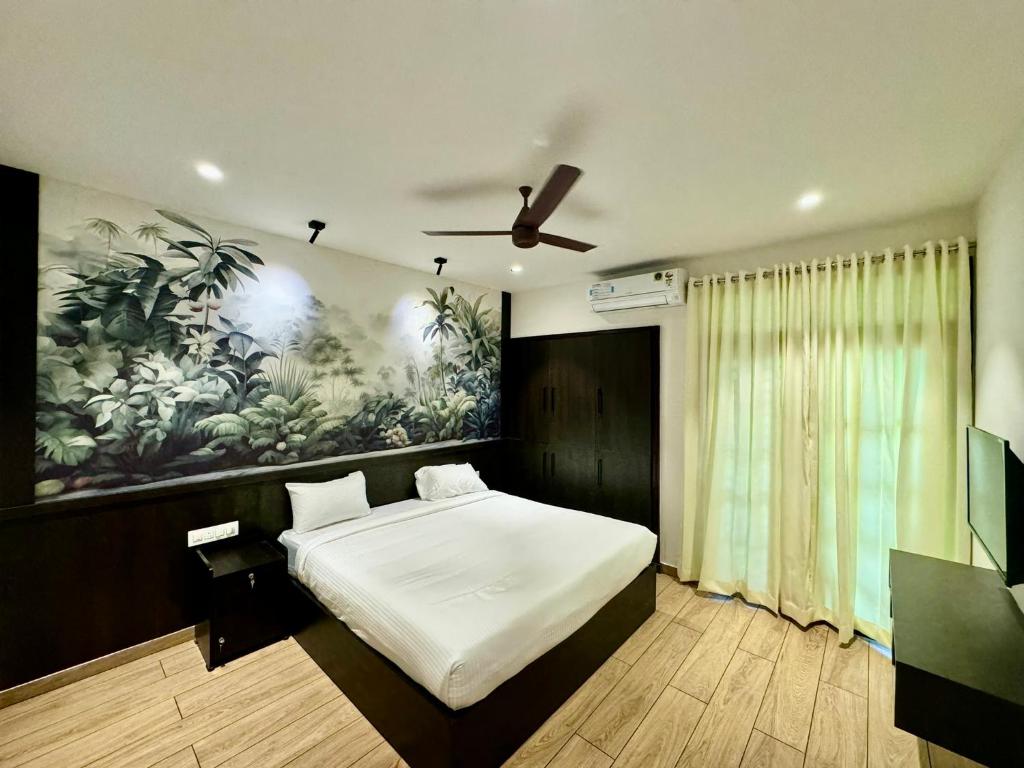 1 dormitorio con 1 cama y una pintura en la pared en Reach Homes, en Kochi
