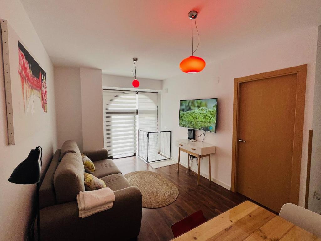 a living room with a couch and a television at GALA Apartamentos Renacimiento - parking gratis in Badajoz