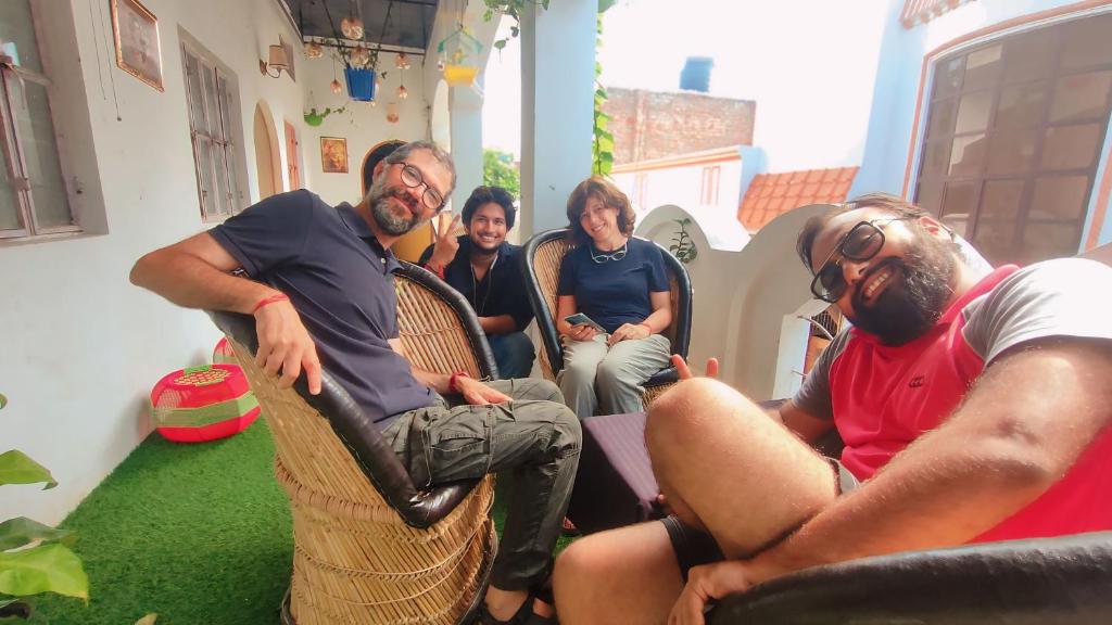 a group of people sitting in chairs in a room at Manavi Home Stay in Mathura