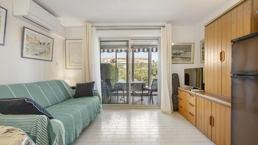 un salon avec un canapé et une télévision dans l'établissement Santa Monica 2- 144E- Appart jardin- 4 pers, au Cap d'Agde