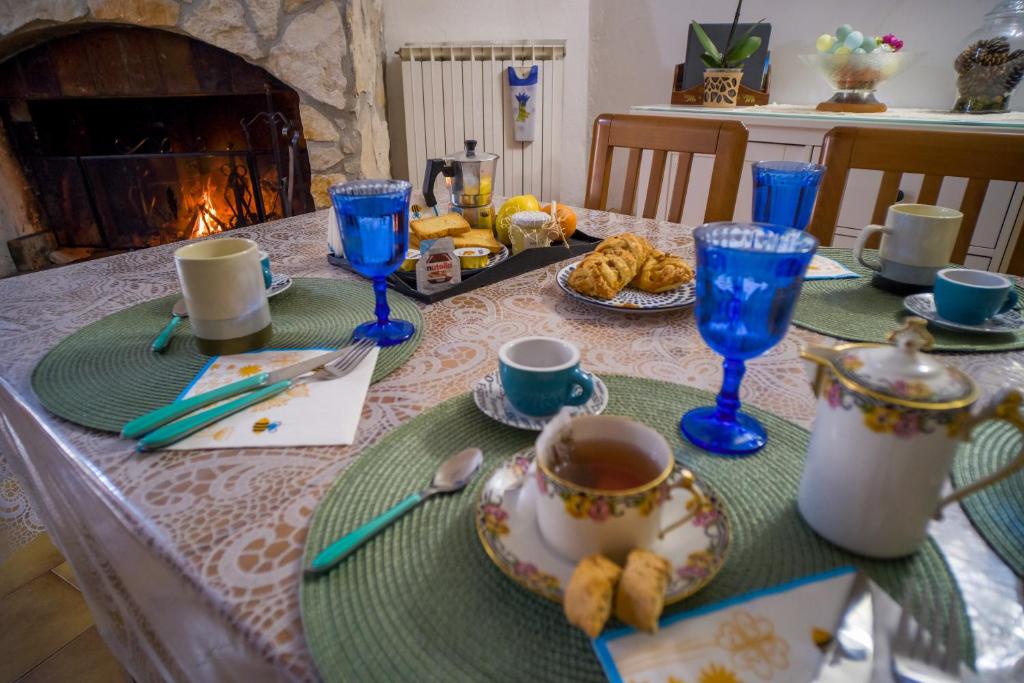 uma mesa com uma toalha de mesa com óculos azuis e comida em Casa Maja - Sant'Eufemia a Maiella em SantʼEufemia a Maiella