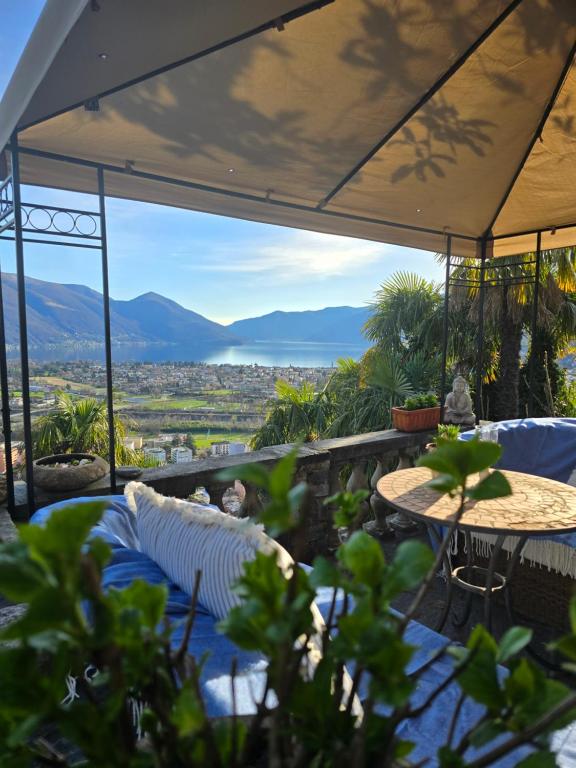 a patio with tables and a view of the mountains at Pensione Olanda in Locarno