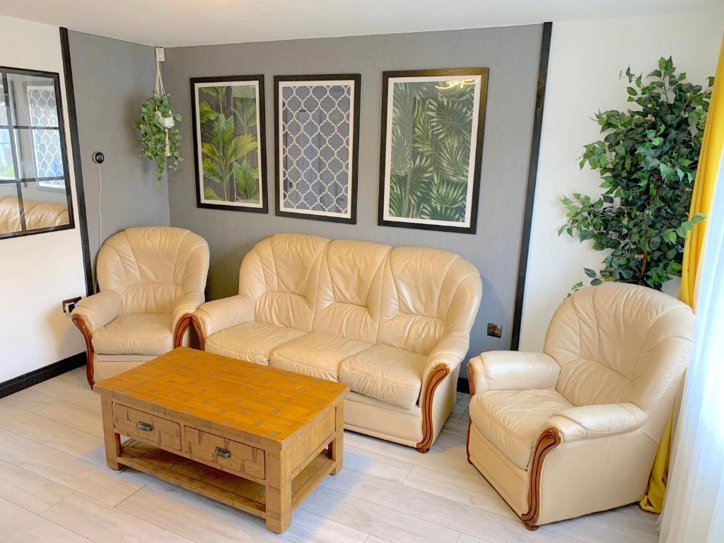 a living room with two leather chairs and a coffee table at Windy House in Sheffield