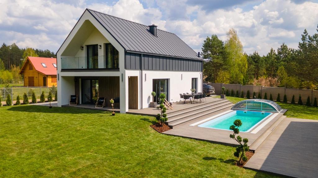 una casa con piscina en el patio en Luxury House Masuria, en Jabłonka