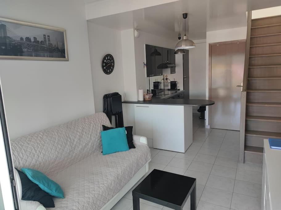 un salon avec un canapé et une cuisine dans l'établissement Studio avec Mezzanine classé 3 etoiles en bord de Mer, à Saint-Cyprien