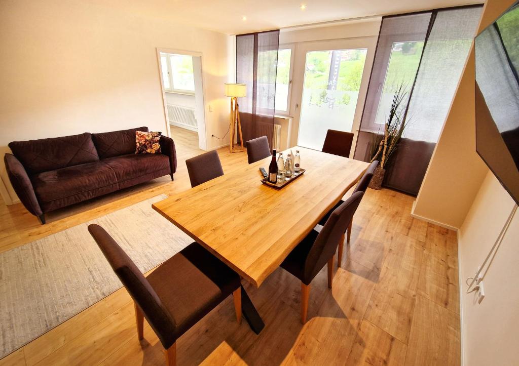 a living room with a wooden table and chairs at Luxus mit Schwarzwaldromantik pur! in Ottenhöfen