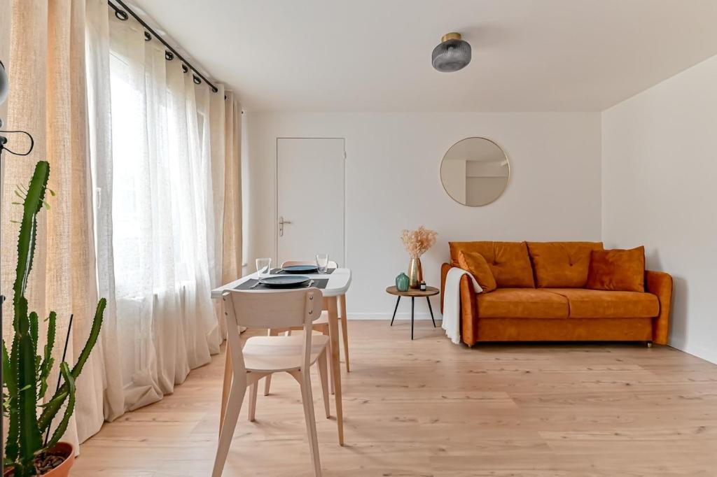 un salon avec un canapé orange et une table dans l'établissement Appartement cosy proche de Paris, à Bagnolet