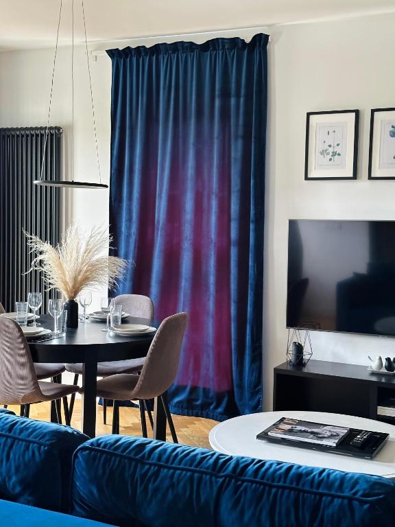 a living room with a table and a blue couch at UNIQUE Apartment with parking in Toruń