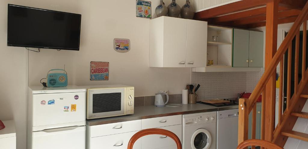 une cuisine avec un réfrigérateur et un micro-ondes dans l'établissement Petite maison en Ardèche, à Saint-Martin-dʼArdèche