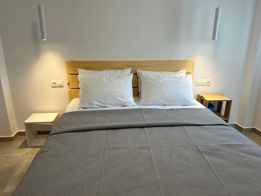 1 cama grande con 2 almohadas y 2 mesas en Aspras Apartments, en Koutsounari
