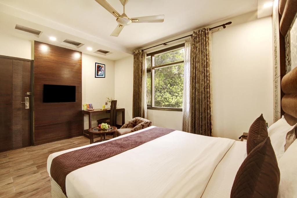 a hotel room with a bed and a window at Hotel Good Times Near Metro in New Delhi