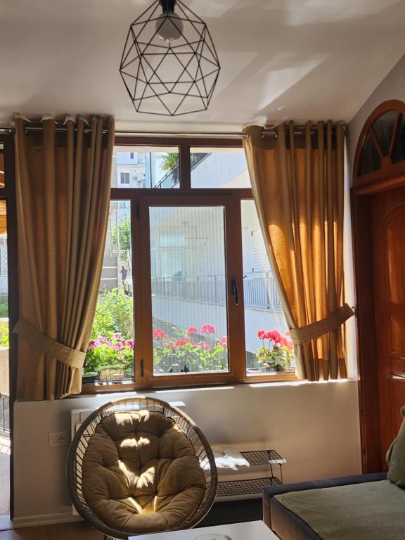 um quarto com uma cadeira em frente a uma janela em Dhami Apartment em Gjirokastër