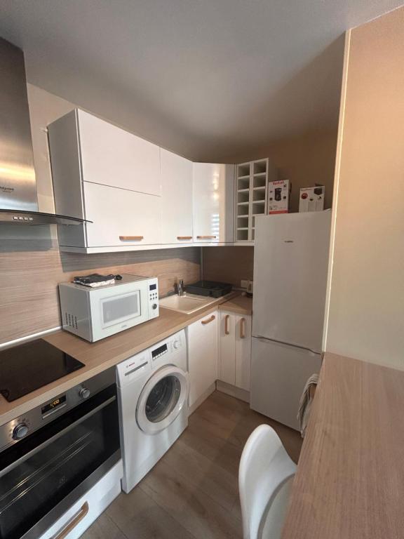 małą kuchnię z pralką i kuchenką mikrofalową w obiekcie Charmant appartement F1 w mieście Saint-Dizier