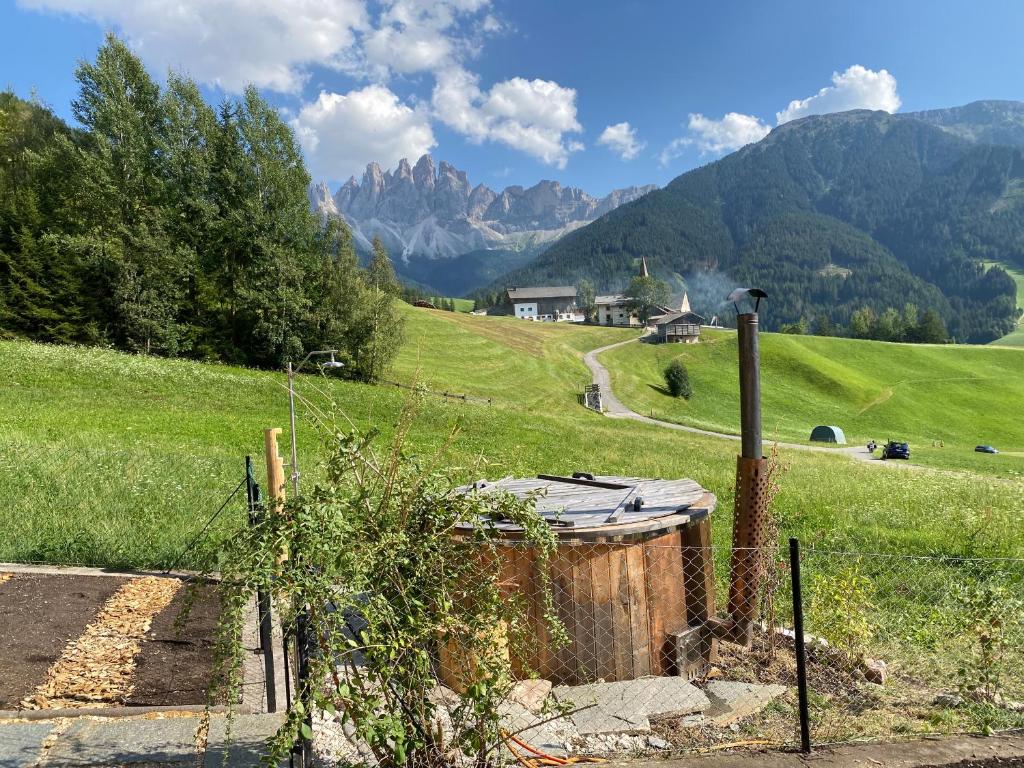 a fence in a field with mountains in the background at Farmhouse with a stunning view over the dolomites in Villnoss