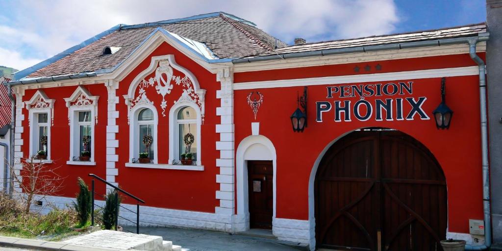 a red and white building with a black door at Pension Phönix in Sighişoara