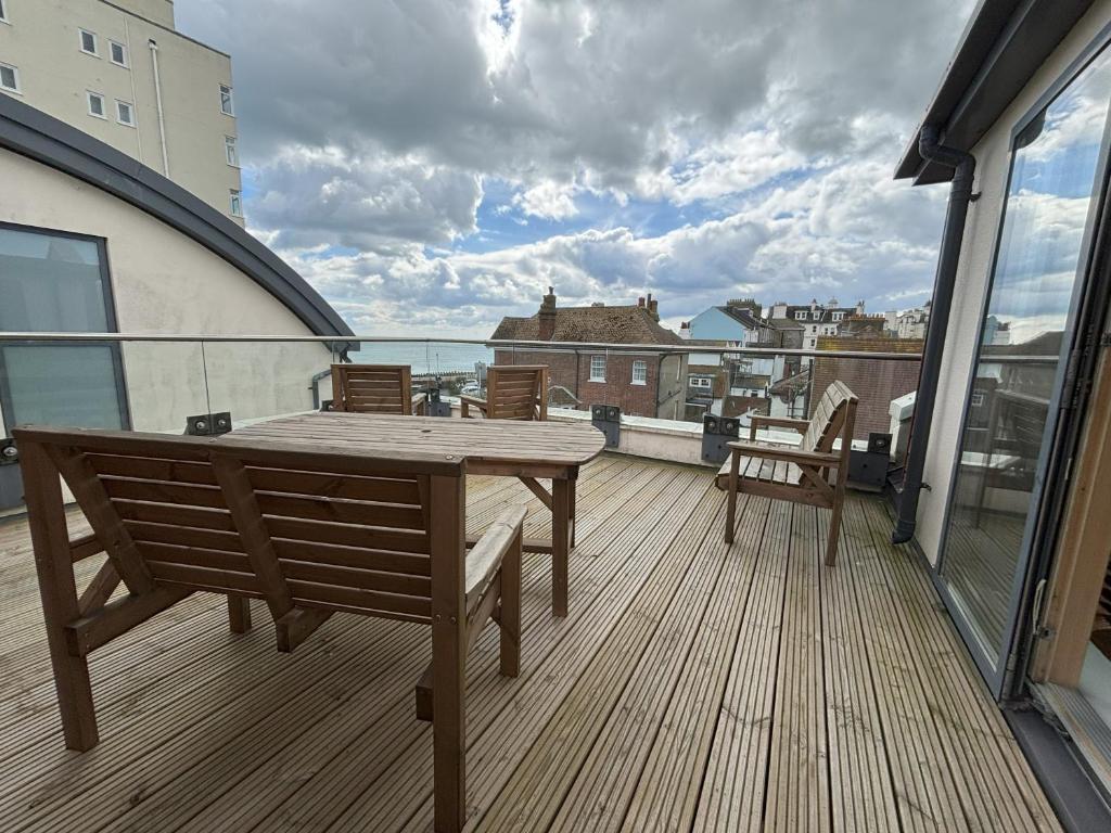 a wooden deck with a table and chairs on a balcony at Millgrove House Apartments in Eastbourne