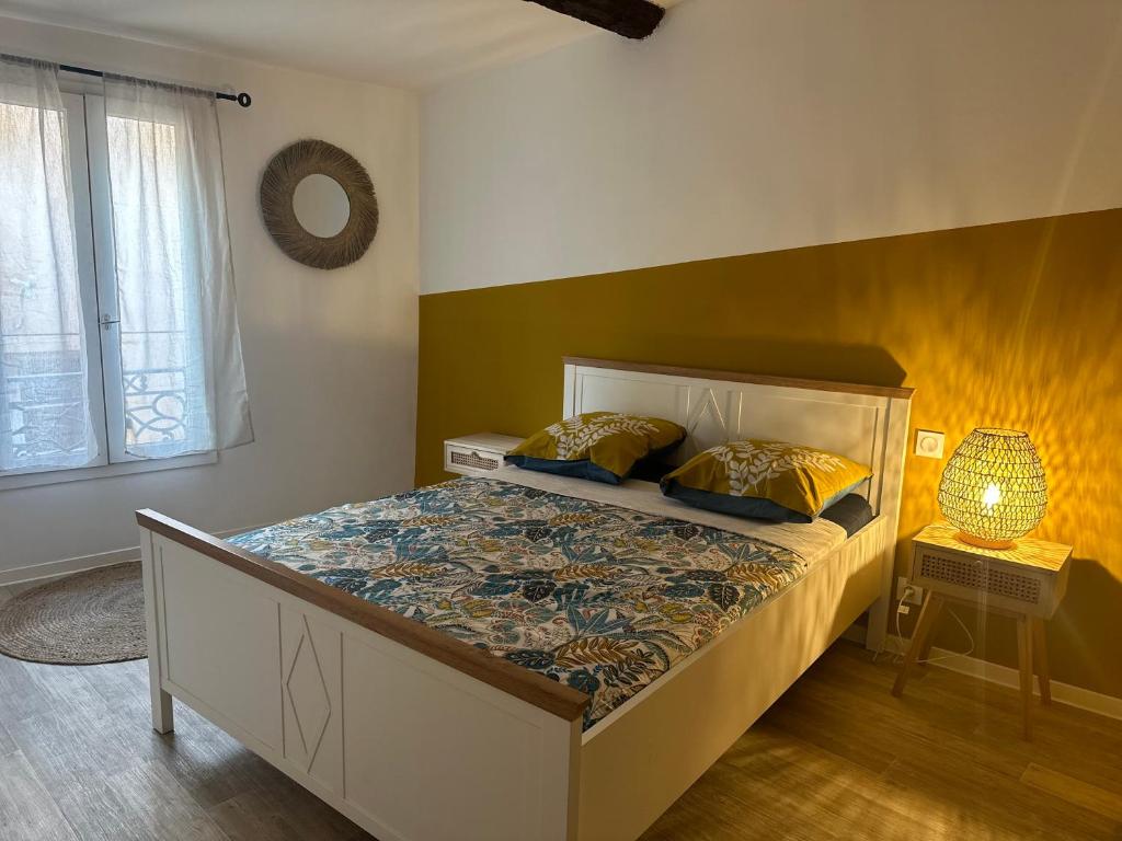a bedroom with a bed and a lamp and a window at COCON CENTRAL - Cathédrale & Castillet - Parking Gratuit - Wifi in Perpignan