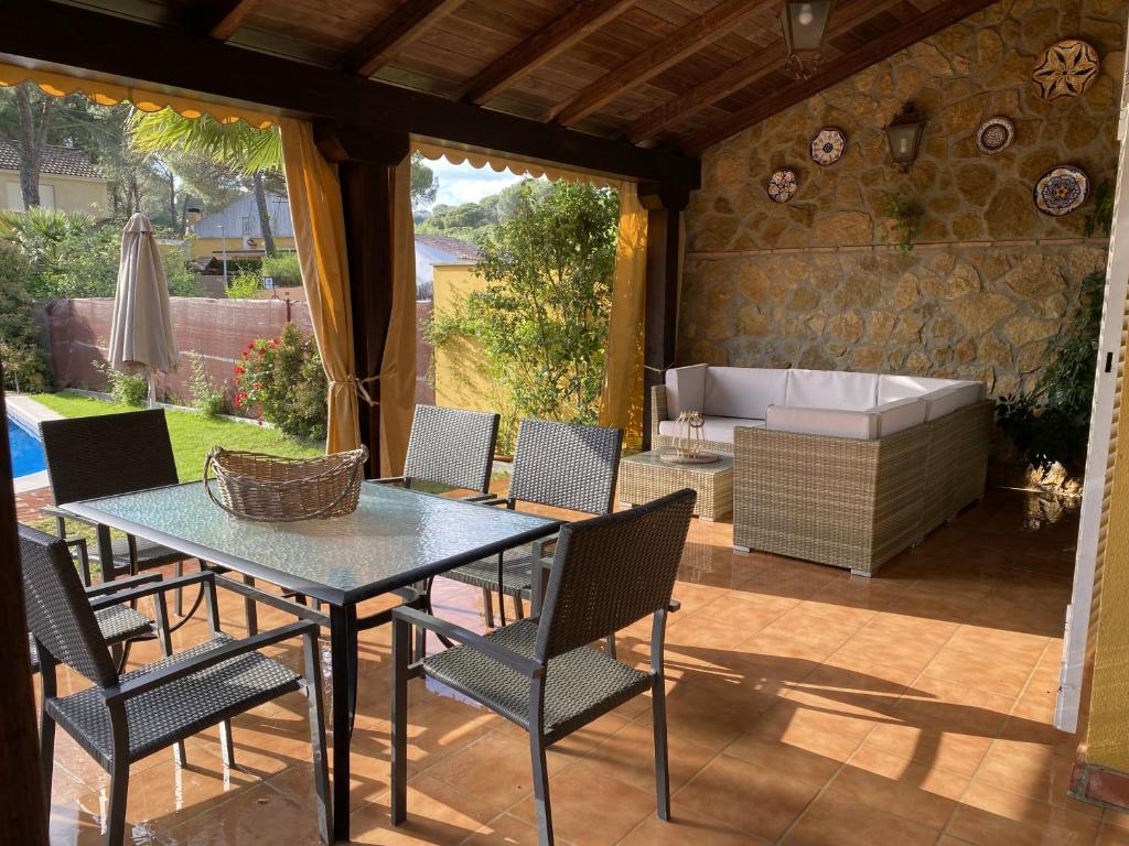 a patio with a table and chairs and a tub at Casa la Querencia del Lago Alojamiento Rural in Las Jaras