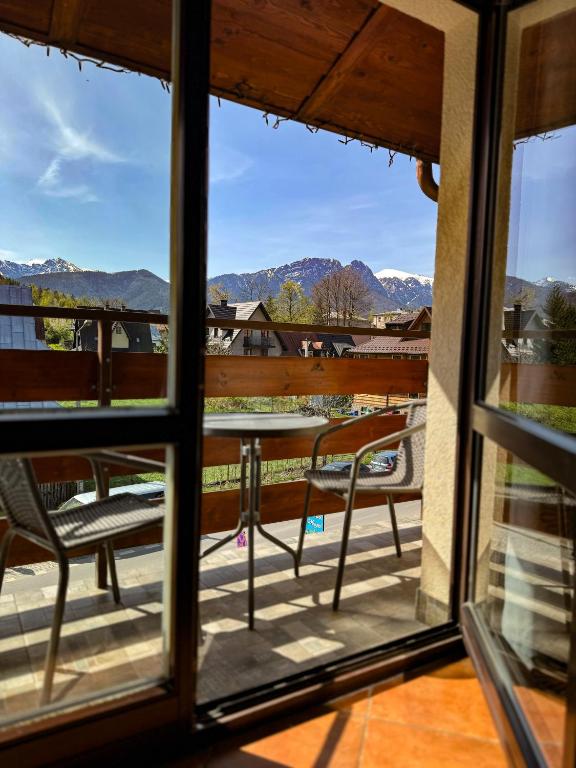 Blick aus einem Fenster auf eine Terrasse mit einem Tisch und Stühlen in der Unterkunft Apartamenty U Anki in Zakopane