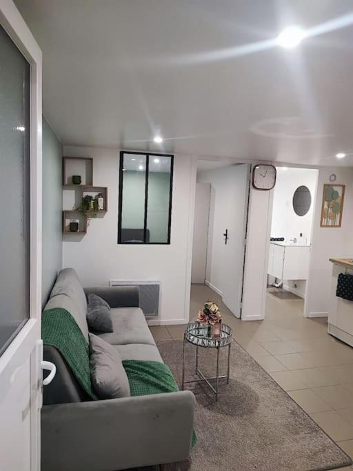 un salon avec un canapé et une table dans l'établissement l'échappée verte, à Le Mée-sur-Seine