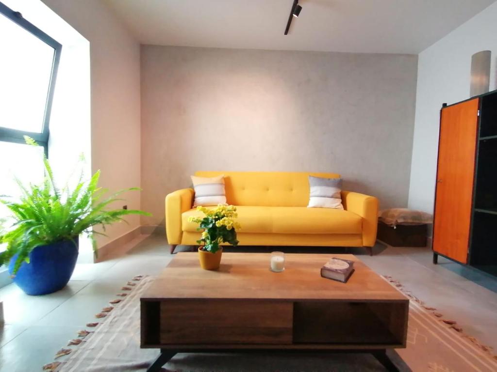 un soggiorno con divano giallo e tavolino da caffè di Casa do Favinha a Machico