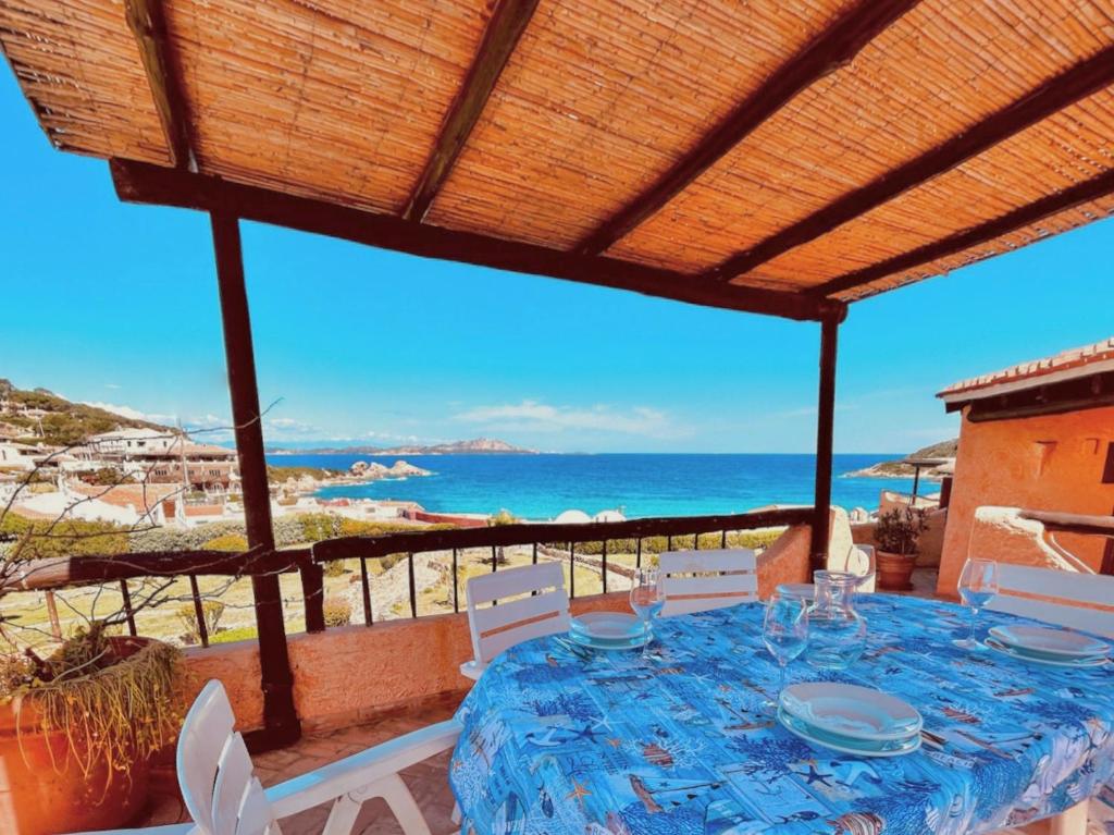 una mesa en un balcón con vistas al océano en Beach Home Baja Sardinia, en Baja Sardinia