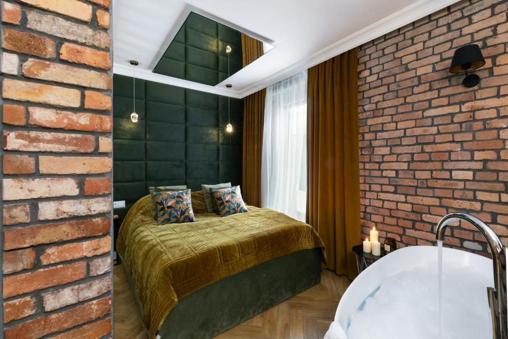 a bedroom with a bed and a brick wall at Fancy Apartment Nikiszowiec in Katowice