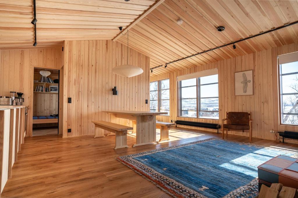 a living room with a table and a kitchen at Kalamaja Kilpisjärvi in Kilpisjärvi