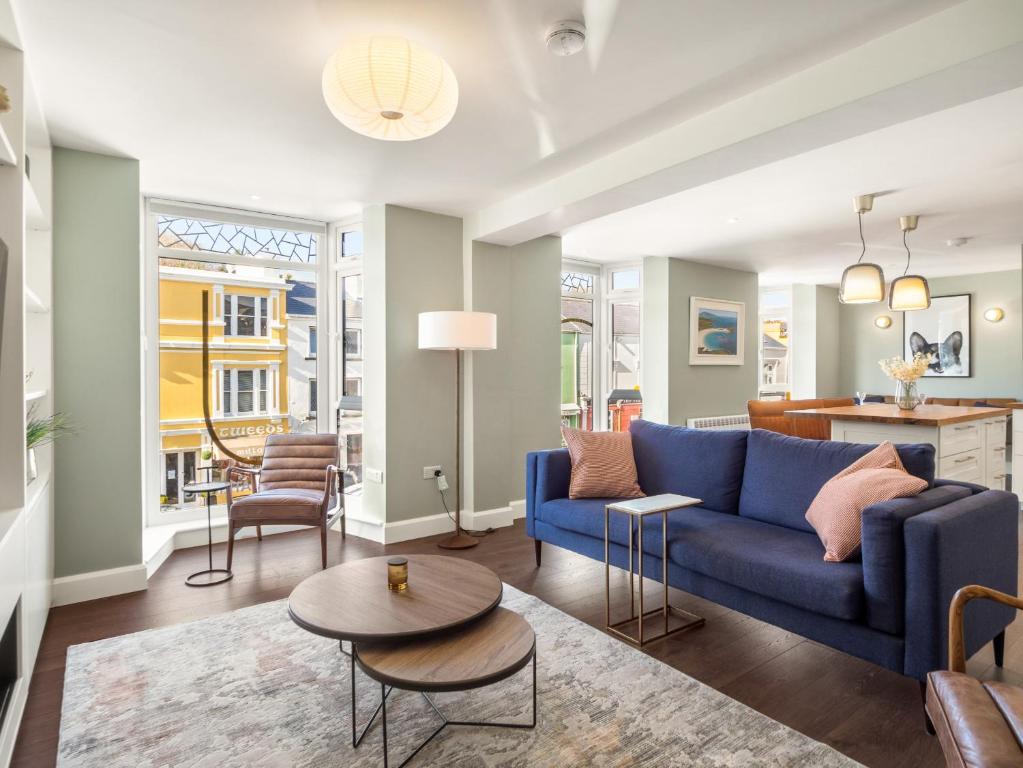 uma sala de estar com um sofá azul e uma mesa em The Executive at Clifden Boutique Apartments em Clifden