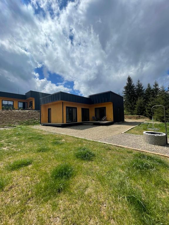 une maison avec un toit noir et une pelouse dans l'établissement Carpathians View, à Krivopolʼye