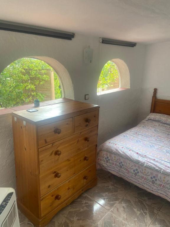a bedroom with a bed and a wooden dresser at Cute Little Casita in Mijas