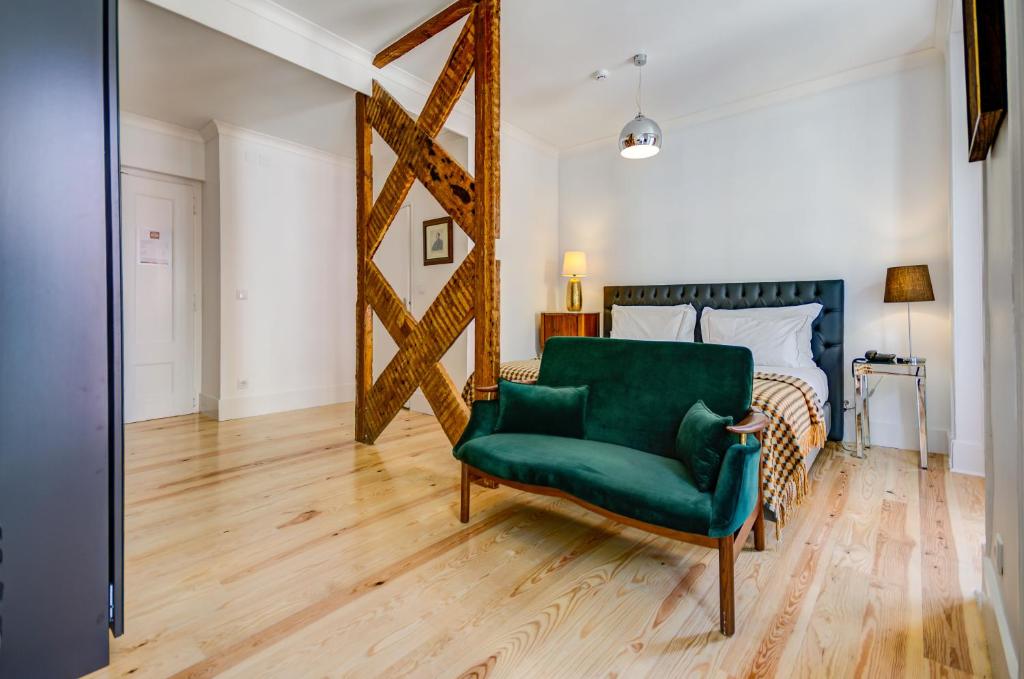 une chaise verte dans une chambre avec un lit dans l'établissement Quinta Colina by Shiadu, à Lisbonne