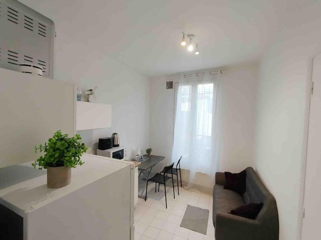 a kitchen and living room with a couch and a table at Cozy Polo's House in Bagnolet