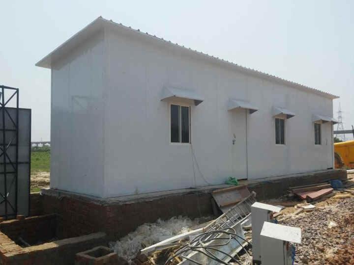 ein weißes Haus, das mit einem Gebäude gebaut wird in der Unterkunft Containers house in Meerut