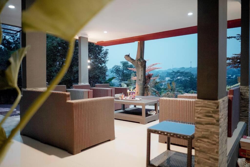 d'une terrasse avec une table et des chaises et une vue. dans l'établissement Warm Pool Mt Villa Teras Teduh, à Karangtengah