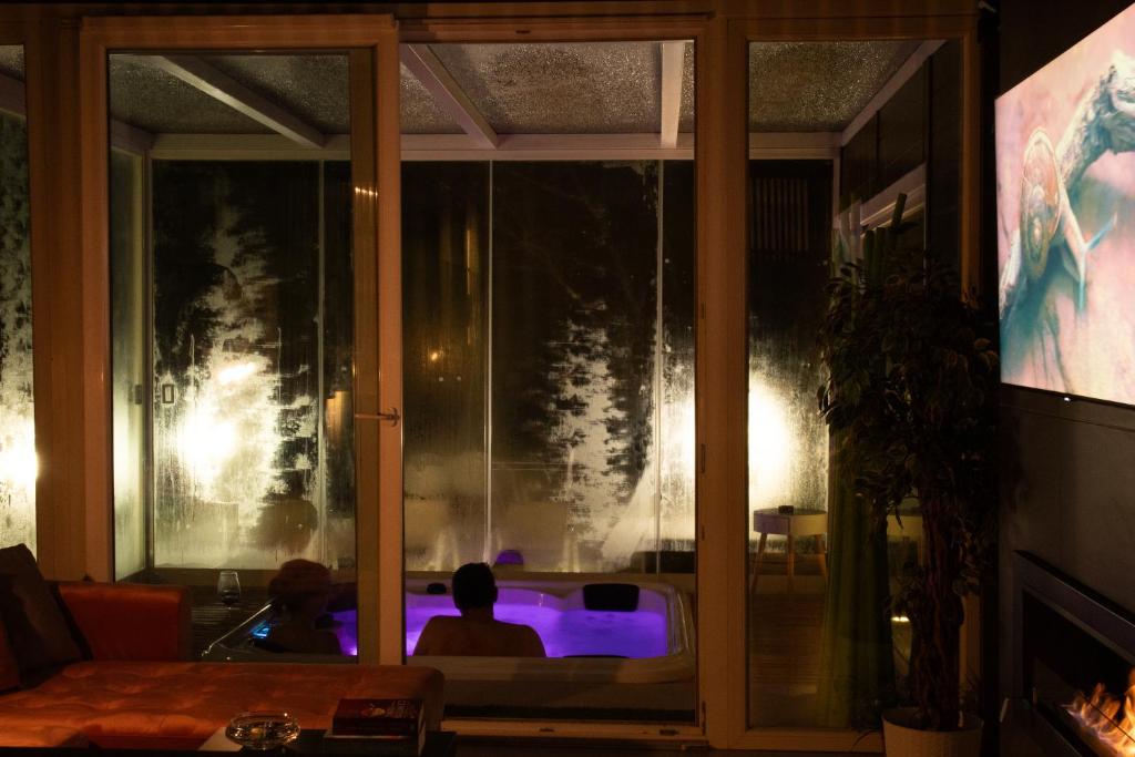 dos personas sentadas frente a una ventana con luces púrpuras en Spera Luxury, en Monreale