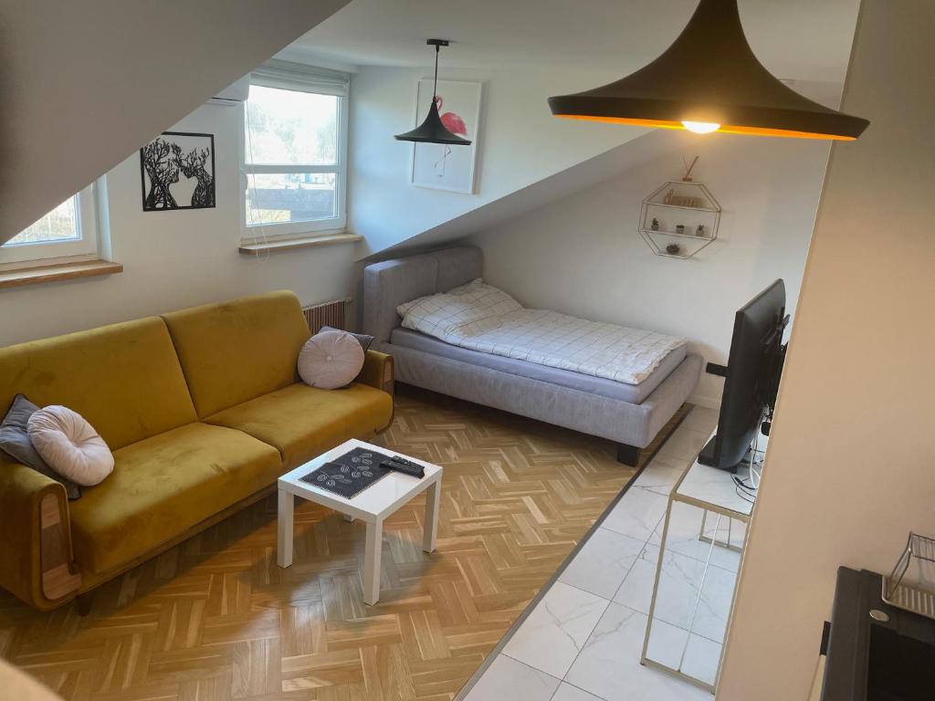 uma sala de estar com um sofá e uma cama em Kawalerka premium B 30m2 - po remoncie - nowa! em Varsóvia