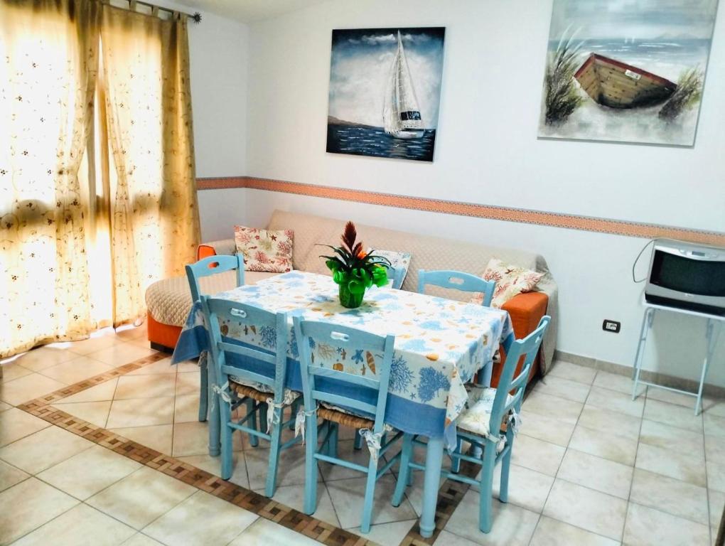 a dining room with a blue table and chairs at Casa Liberty in Villasimius