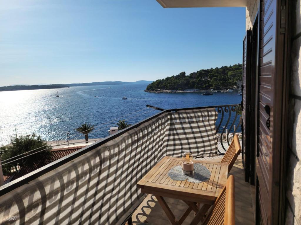 a balcony with a table and a view of the water at Apartments Caric in Hvar
