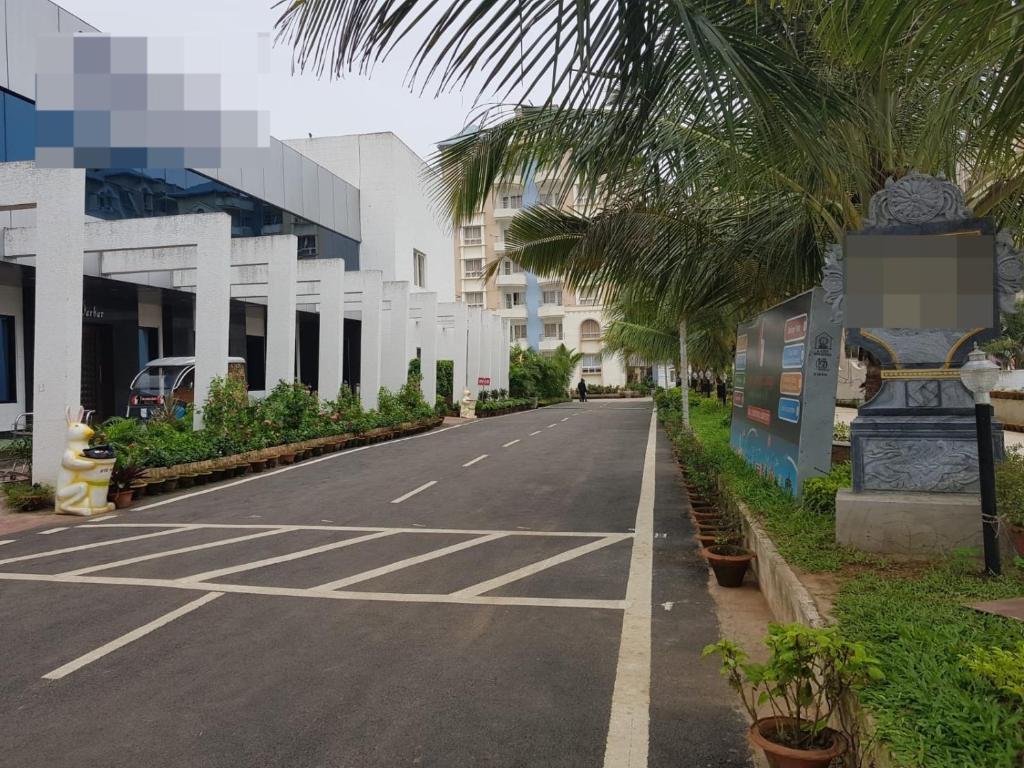 an empty street with palm trees and a building at Liberty Resort in Puri