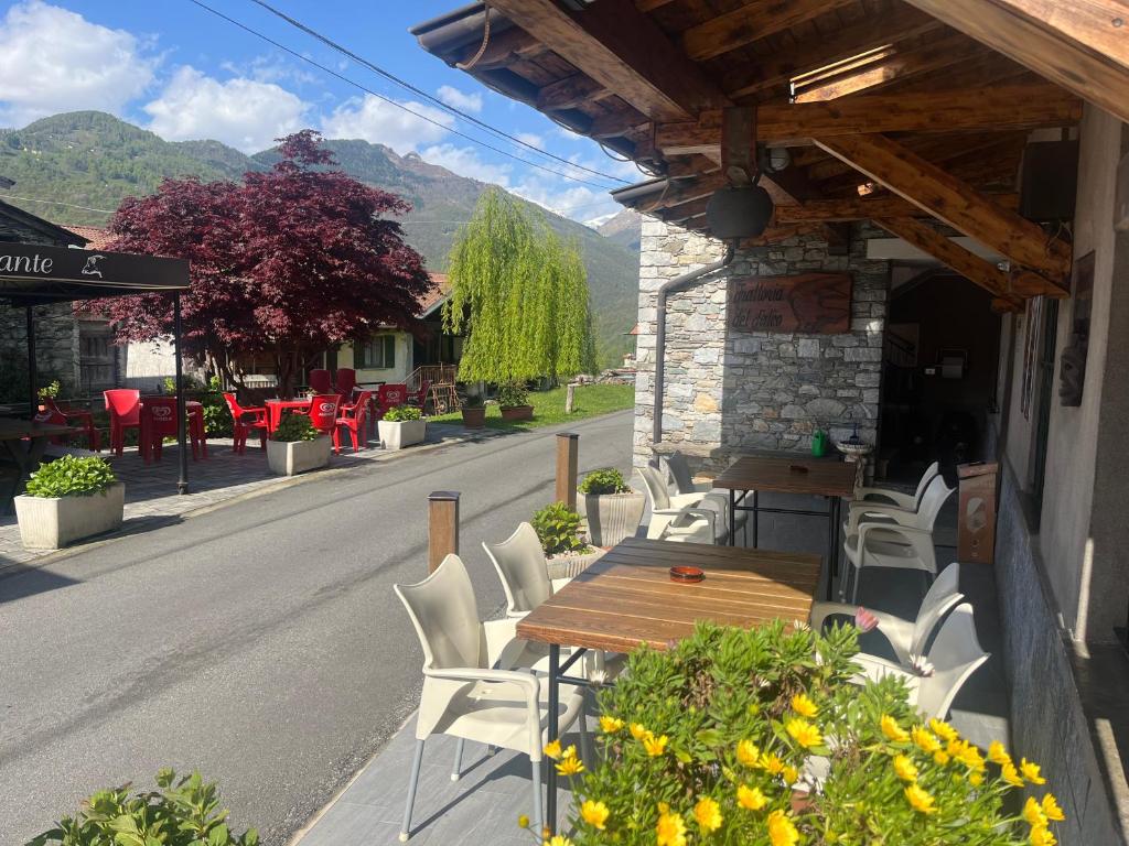 een patio met een tafel en stoelen in een straat bij Hotel del Falco in Gravedona