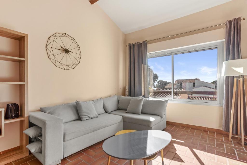 ein Wohnzimmer mit einer Couch und einem Glastisch in der Unterkunft Domaine de la Gaillarde in Roquebrune-sur-Argens