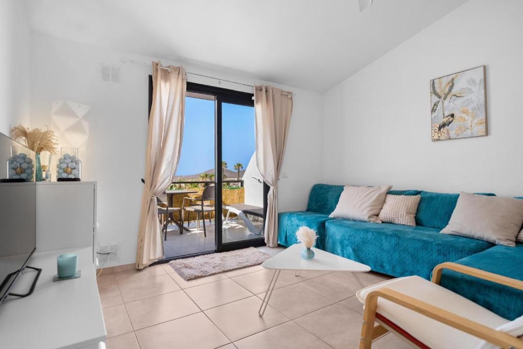 サンミゲル・デ・アボナにあるAmarilla Golf Apartmentのリビングルーム(青いソファ、バルコニー付)